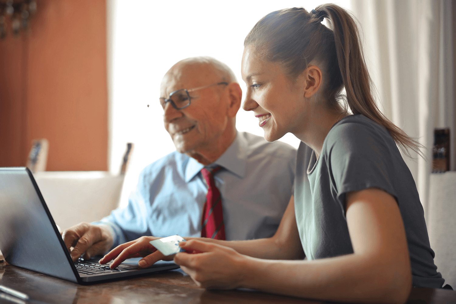 Smiling woman and man in front of a laptop, writing online reviews