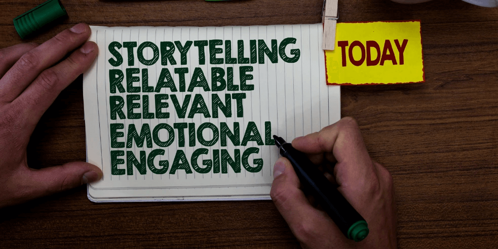 Male hands on a notebook writing the words 'Storytelling,' 'Relatable,' 'Relevant,' 'Emotional,' and 'Engaging