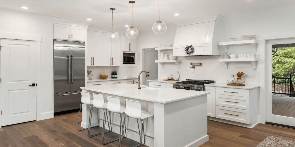 Kitchen with all-white cabinets and luxury vinyl floor mimicking wood