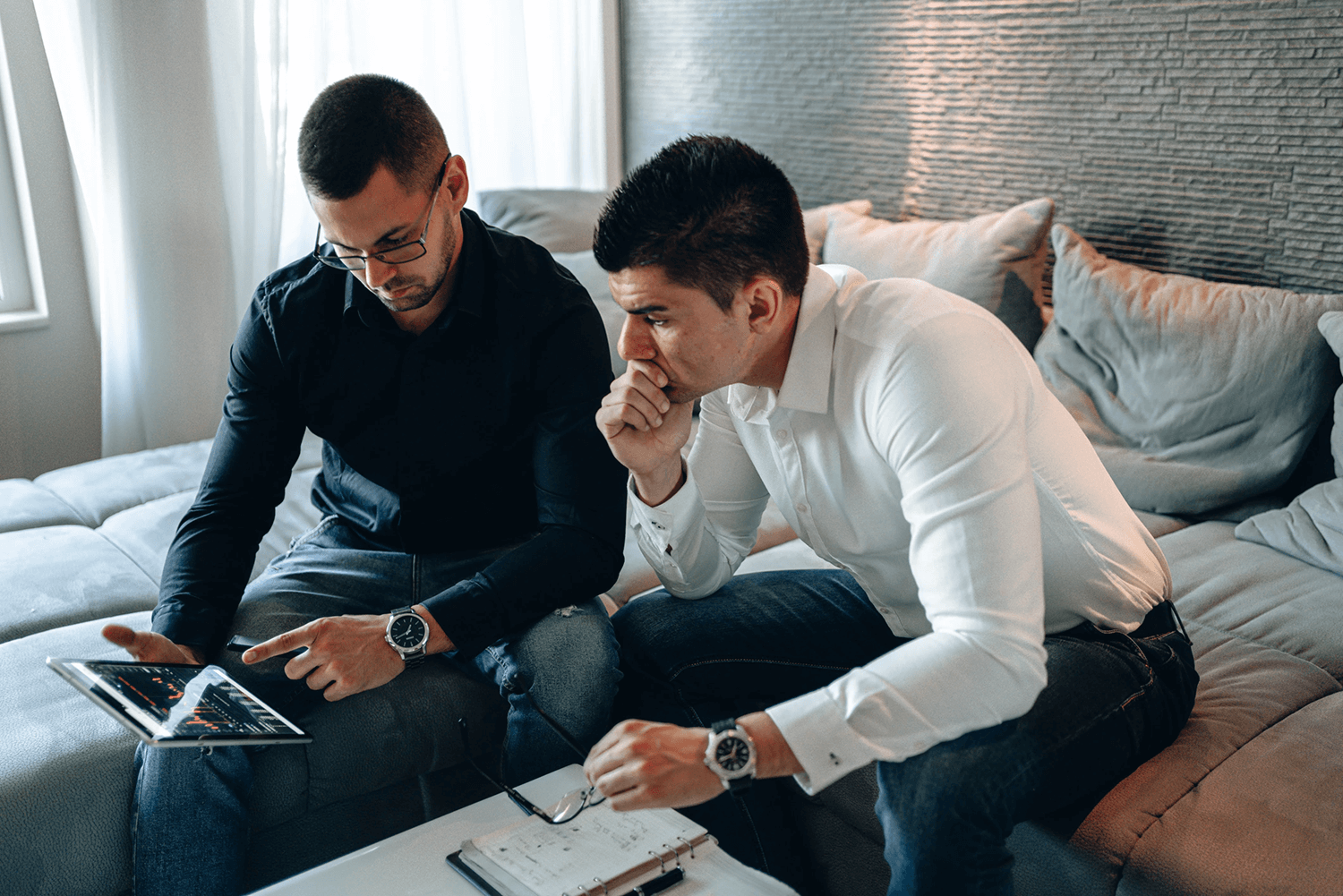 Two coworkers looking at data on a tablet and discussing changes learned from negative feedback