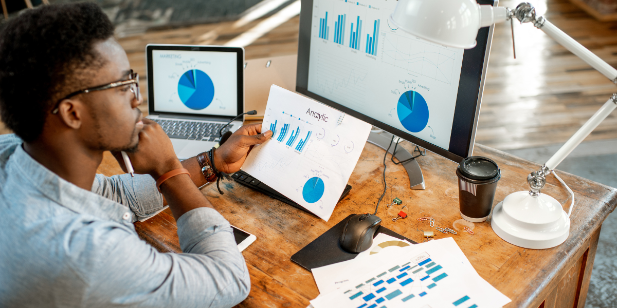 A person looking at a laptop with a graph showing national SEO performance