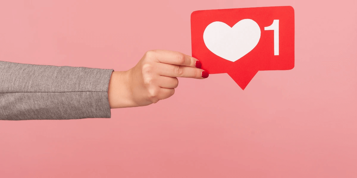 Closeup of hand holding social media like/heart icon
