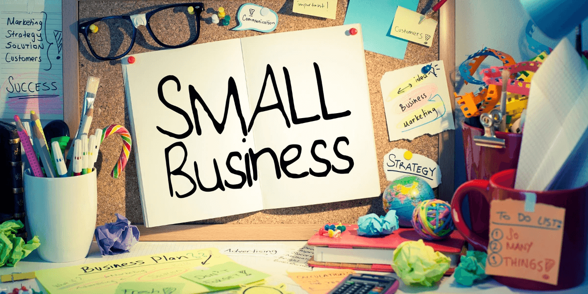 Small Business sign pinned to a corkboard next to colorful pens and papers on a desk