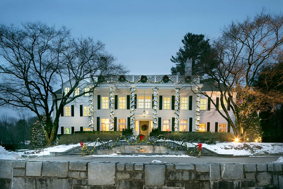 A stately home glows with festive holiday lights