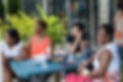 Image of event goers sitting at a picnic table, enjoying food and conversation at a St. Luke Legacy Center event.