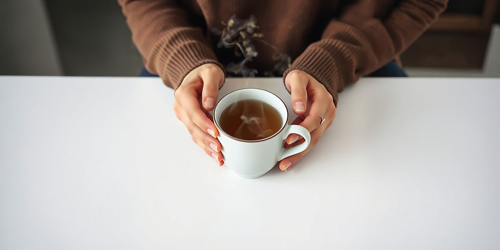 A close-up of a person's hands cradling a steaming cup of herbal tea on a clean, simple table, with steam gently rising from the mug, symbolising a moment of peace.