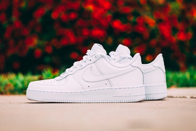 sepatu nike air force 1 warna putih dengan background taman yang blur