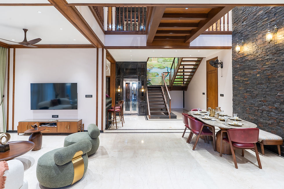 Modern living-dining room with staircase, TV, set dining table, stone accent wall, and green sculptural chairs in a bright home interior