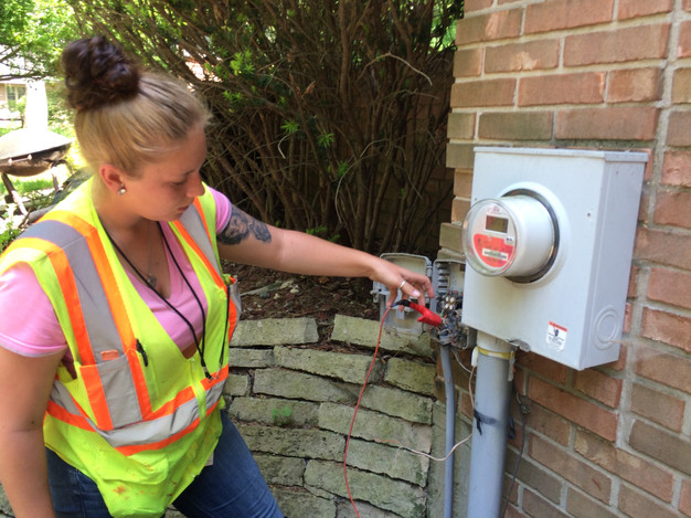 A technician establishes a new ground for the phone line before surveying the ground.