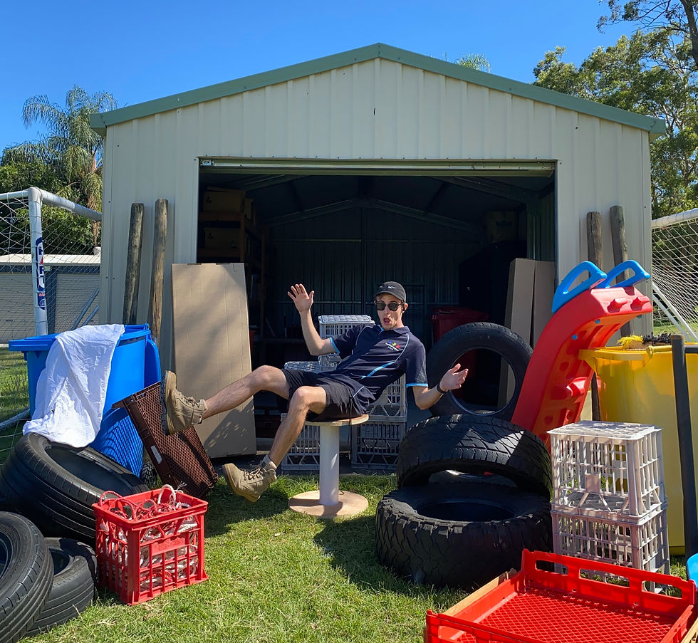 Nathan pulling a silly pose surrounded by loose parts equipment.