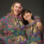 two women smiling in hoodies