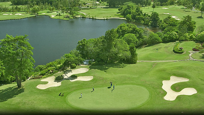 Phuket Country Club, established in 1989, was the first golf course in Phuket and offers two courses: the 18-hole Old Course and a newer 9-hole Country Club Course. The Old Course is known for its challenging layout and scenic beauty, featuring a mix of undulating fairways, bunkers, and water hazards. The Country Club Course is more compact and features water hazards on most holes. Both courses are set amidst the rolling hills and limestone cliffs of Phuket.
Key Features:
Old Course:
18-hole, par 72, 6,484 yards, featuring undulating terrain, limestone cliffs, and water hazards.
Country Club Course:
9-hole, par 36, featuring water hazards on most holes.
Driving Range:
A 52-bay, floodlit driving range is centrally located between the two courses.
Clubhouse:
Well-equipped with a pro shop, putting green, tennis courts, and a restaurant serving Thai and American cuisine.
Location:
Conveniently located within 20-30 minutes of Phuket City, Patong, and other popular areas.
History:
Hosted numerous tournaments, including the LADIES KOSAIDO THAILAND OPEN 1992 and the THAI SENIOR PGA CHALLENGE 2002.
Caddies:
The course does not offer carts, and caddies use wheeled dollies to transport clubs.
Notable Holes:
Old Course Hole #10: A par 5 with a dogleg right around a large lake, requiring a long carry over water to reach the green in one shot.
Overall:
Phuket Country Club is a popular destination for golfers of all skill levels, offering a challenging and scenic experience with well-maintained courses and excellent facilities. The club's history, convenient location, and beautiful setting make it a must-play for golf enthusiasts visiting Phuket.