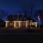 Residential home with column, entry, and flagpole lighting installed by Water Worx at night