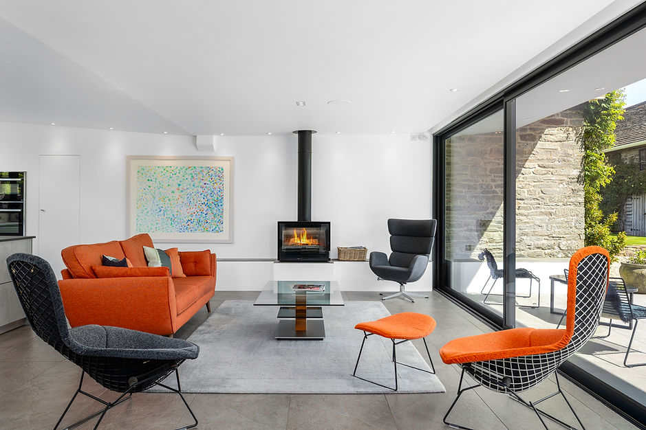Character living room with exposed oak beams, stone fireplace and wood-burning stove