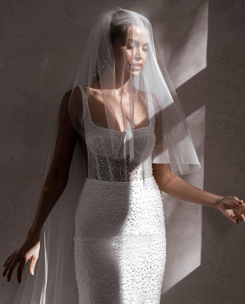 Freddie stuns with intricate pearlescent beading, a Chantilly lace underlay, and a corset-style bodice. Her figure-hugging skirt, featuring a flattering godet, and detachable belt
