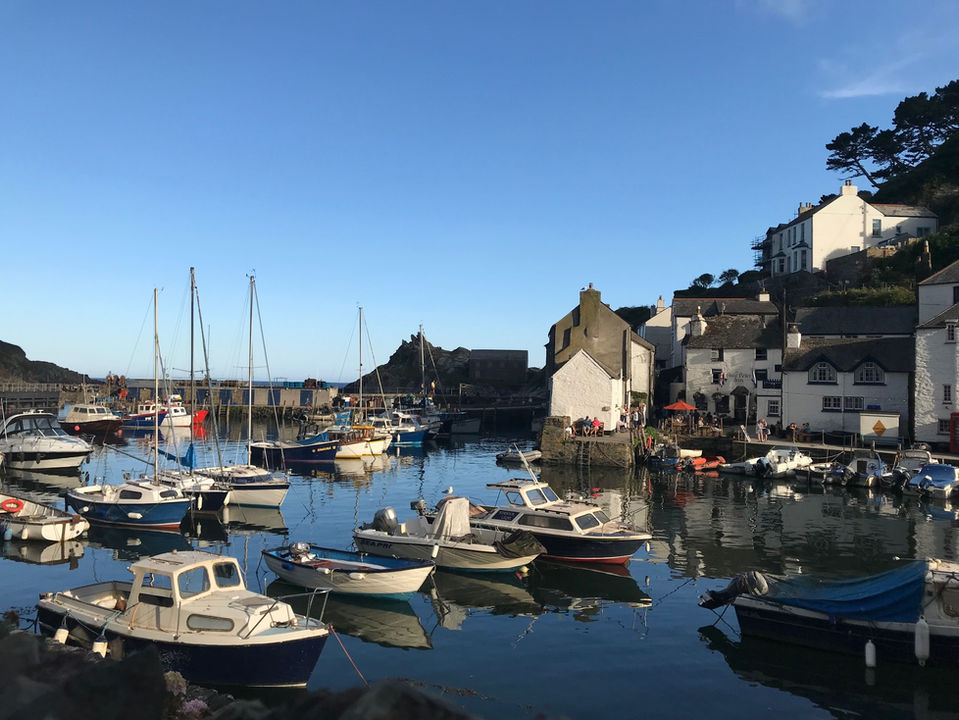 Polperro harbour full of small boats and the surrounding cottages.
