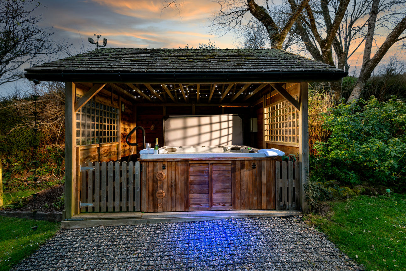Corn Barn large hot tub covered by gazebo with fairy lights for the evening.