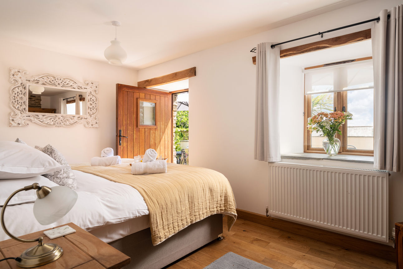 Furnished bedroom with door open to garden.