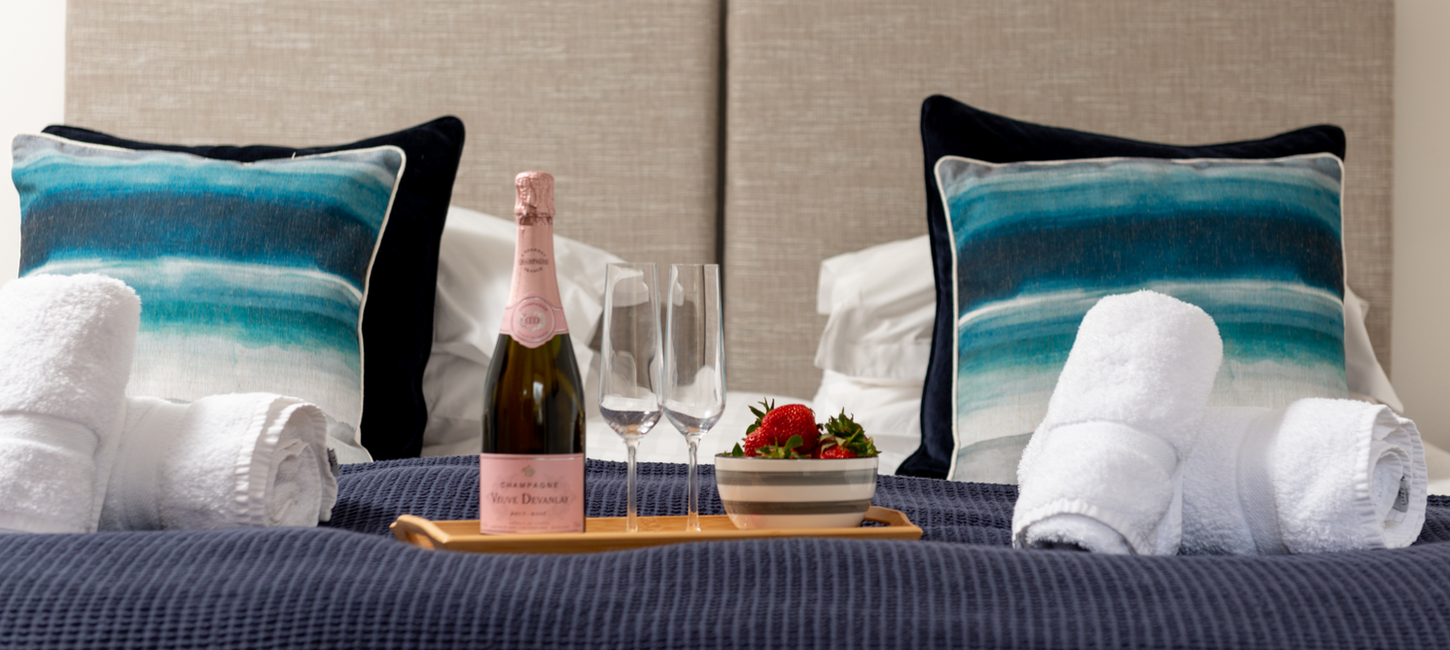 Water Mill bedroom 1. with towels and tray of champaign and strawberries.