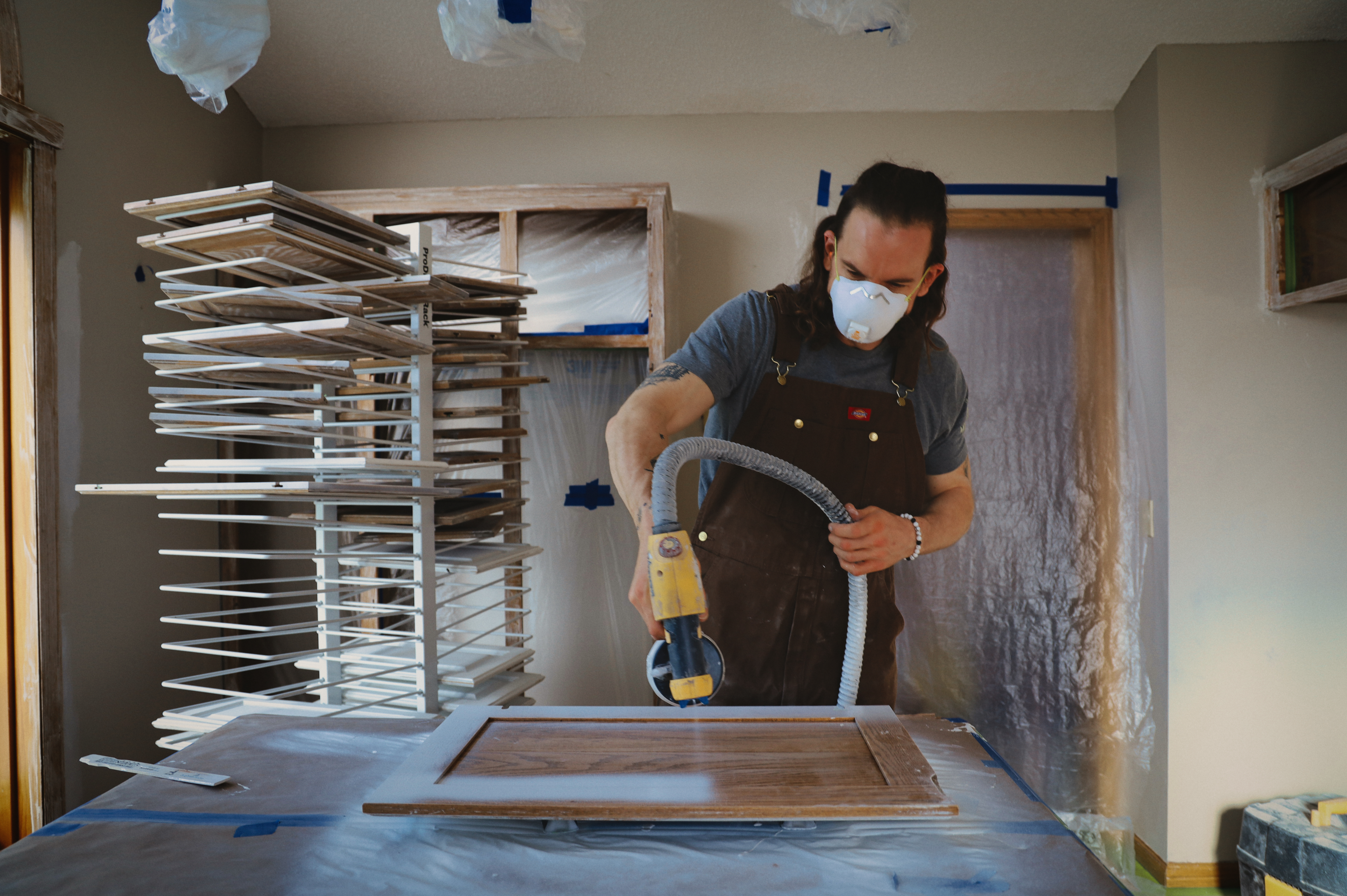 Ryan sanding a cabinet door during surface preparation