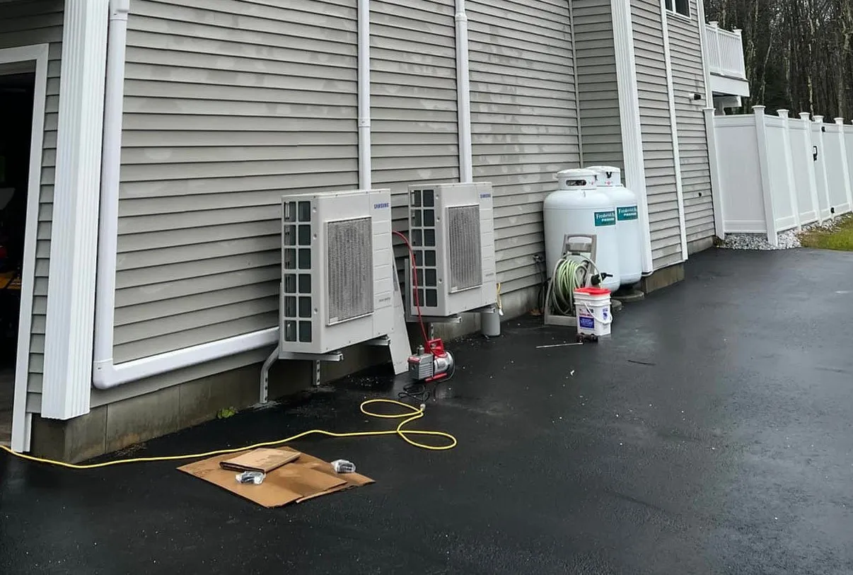 Two Samsung heat pumps installed outside on the side of a house