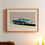 Thumbnail: A cosy bedroom interior featuring a framed illustration of a classic blue Porsche 911 S Targa