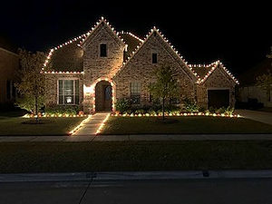 Multi-color LED Christmas lights highlighting hips and ridges and landscape line.