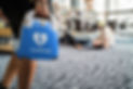A person holds the CardiAngel automated external defibrillator (AED) while approaching a sudden cardiac arrest victim lying on the floor. The image emphasizes the importance of fast response and the life-saving role of accessible defibrillation in public spaces