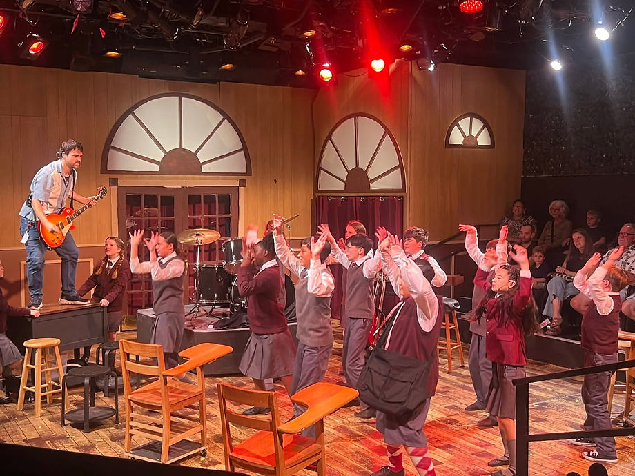 Shot of the cast of Chestnut Street Playhouse's 2025 School of Rock cast dancing on stage