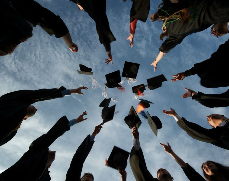 Graduates celebrate by tossing their caps into the air at the end of a commencement ceremony. Photo by: Pinterest.