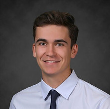 Smiling young man with brown hair, wearing a white shirt with dark tie. Board member.