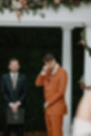 Wedding by Augusta Officiant. A officiant starts a ceremony for a wedding. The grrom stands in a burnt orange suit.