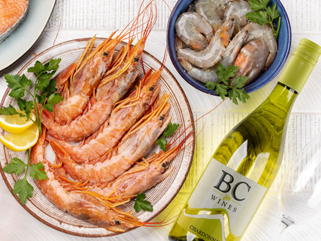 a bottle of chardonnay on a table with plated raw seafood