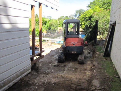 digger clearing land next to pool
