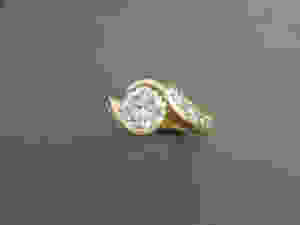 14K yellow gold ring set with one 2.00 carat diamond in the center; accompanied by ten diamonds with a total weight of 1.50 carat.