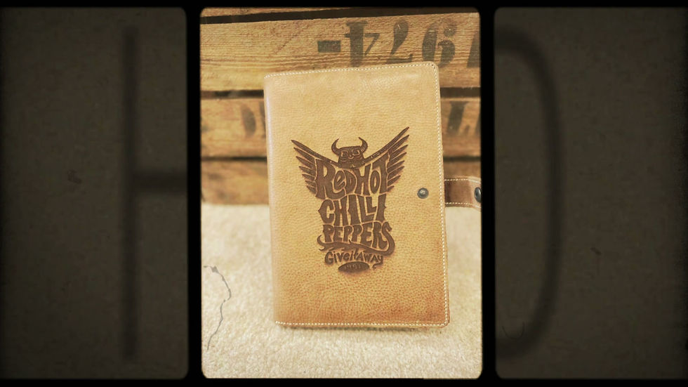 RHCP notebook cover met groot muzieklogo gegraveerd in bruin leer.