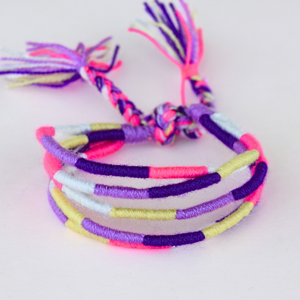 pulsera de gusanitos tejidos en tonos morados, lilas y amarillo