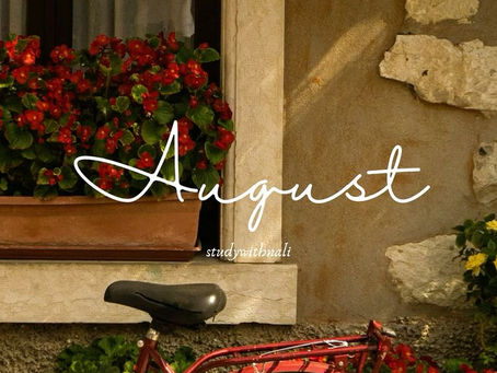 Cozy August aesthetic featuring a vintage red bicycle beside a flower filled window with lush greenery and warm sunlight, creating a peaceful late summer atmosphere.