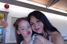 A candid photo captured by the Little Rover roaming photo booth showing a smiling woman hugging a young girl making a playful kissy face at an indoor event.