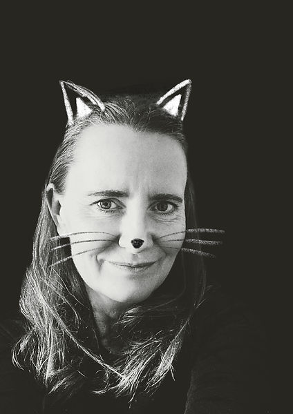 black and white photo of Ros with cat ears, nose and whiskers drawn on her face.