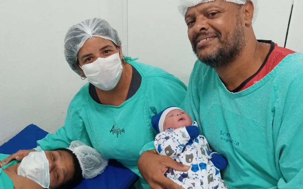 A foto mostra a mãe Débora deitada na maca. A intérprete Thayane está em pé, abraçando a mãe. Ao lado, está o papai Nélson segurando Gustavo no colo. Todos vestem roupa de hospital.