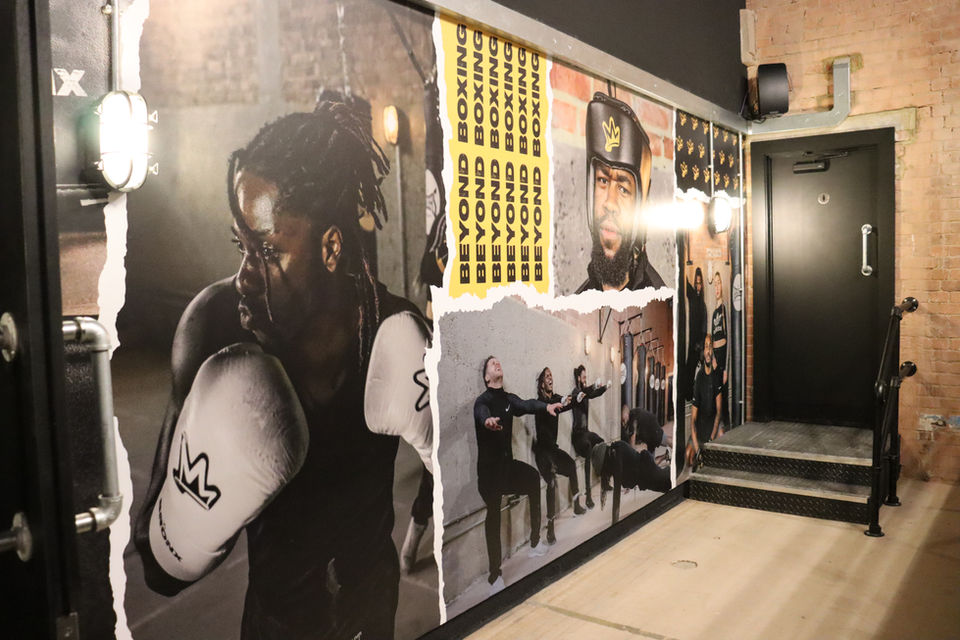 Inside Bronx boxing club in London, showing the hall way and a graphic on the back wall of some of the members. 