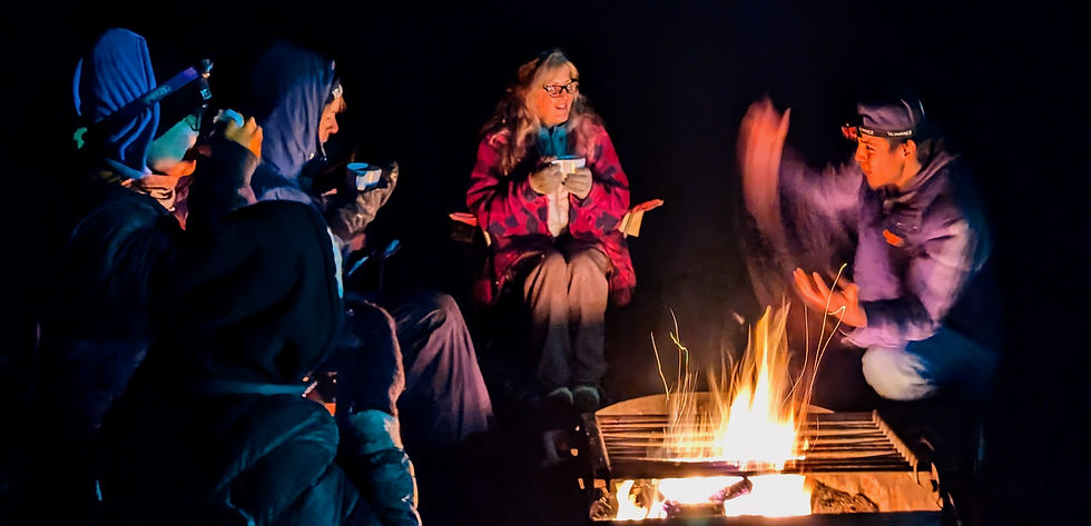 Indigenous guide telling stories to guests around a campfire during an Aurora fireside tour in Yellowknife.