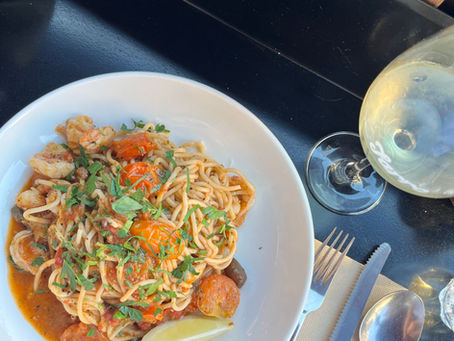 A bowl of spagetti and a wine 