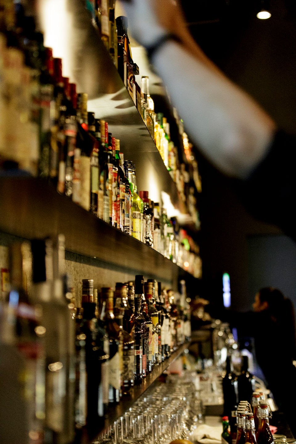 Bar mit vielen Flaschen - Barkeeper an der Arbeit während Neueröffnung Bar in Basel