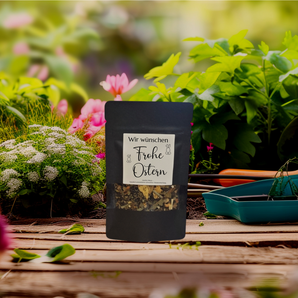 Tee in einer schwarzen, stehenden Verpackung mit Sichtfenster. Aufdruck "Wir wünschen Frohe Ostern"