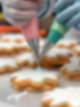 cookies being professionally hand iced with piping bags in kitchen_edited.jpg