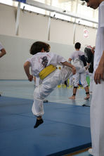 Un niño haciendo una patada en saldo en entrenamiento de taekwondo