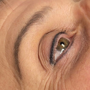 Close-up of permanent makeup brow and eyeliner results showing defined brows and softly enhanced eyes.