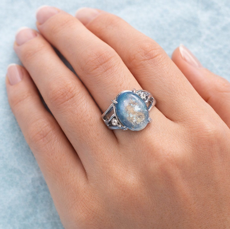 An oval blue keepsake resin stone swirled with soft gold flecks, reminiscent of sky and sea.
Set in polished silver, this timeless ring preserves memory in an elegant, wearable form.